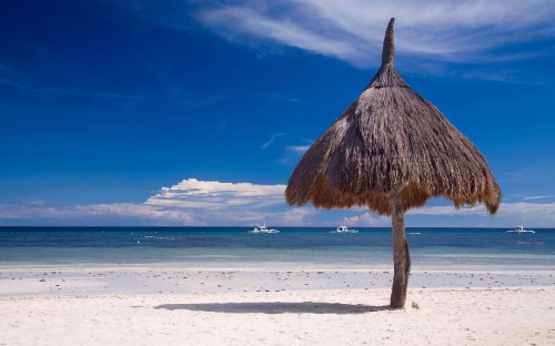 Image brown beach umbrella on white sand beach during daytime