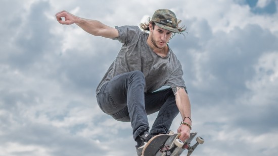 Image man in gray t-shirt and black pants wearing black helmet