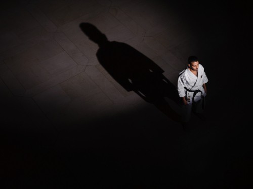 Image man in white dress shirt and black pants walking on white floor tiles