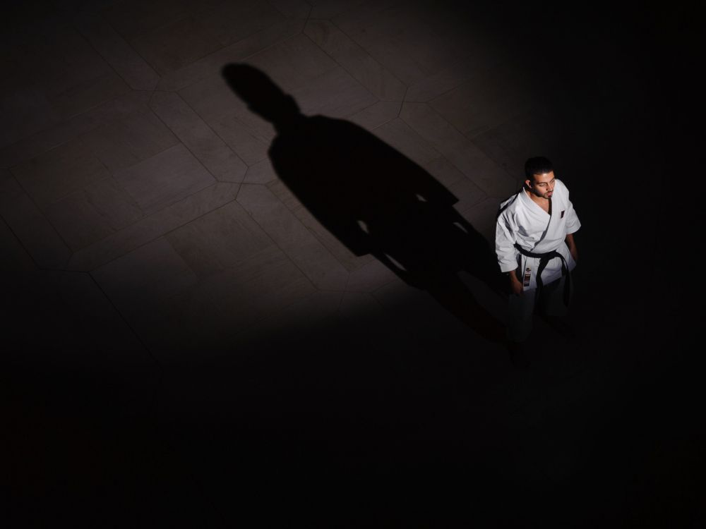 man in white dress shirt and black pants walking on white floor tiles