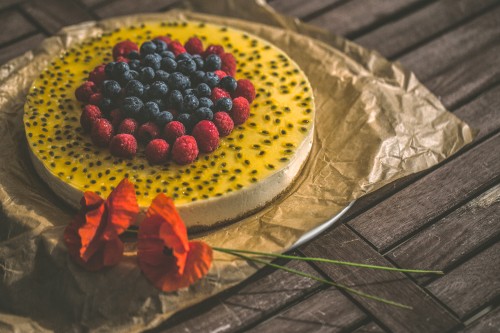 Image red and black berries on white ceramic plate