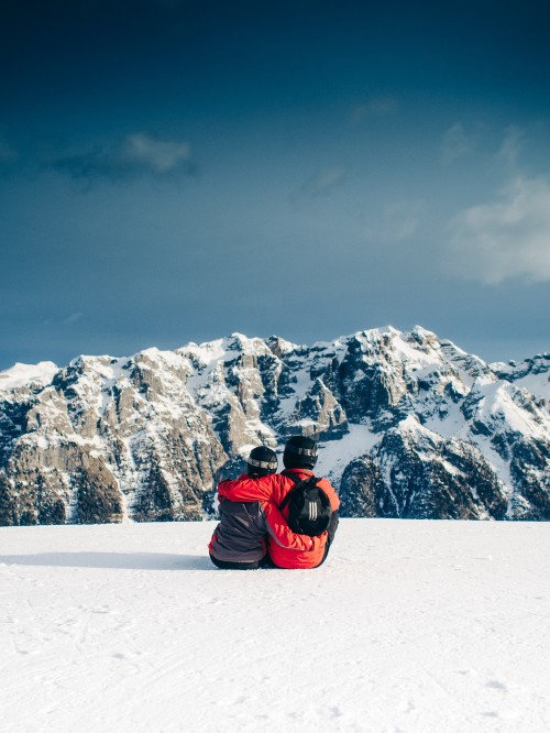 Image person in red jacket sitting on snow covered ground