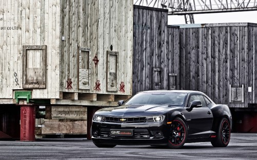 Image black car parked beside brown wooden wall