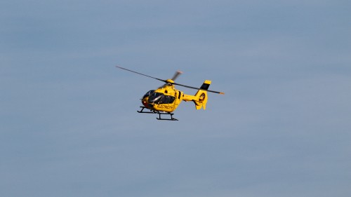 Image yellow and black helicopter flying in the sky