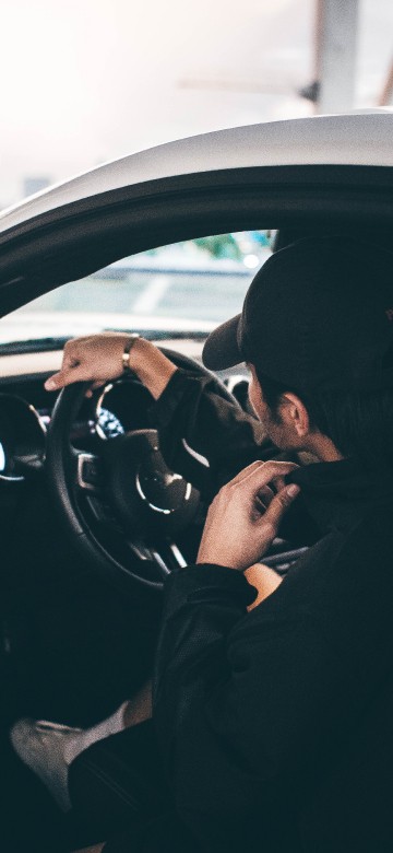 Image man in black jacket driving car during daytime