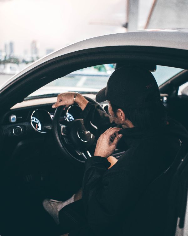 man in black jacket driving car during daytime