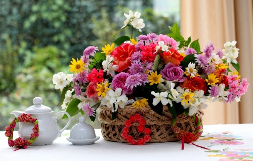 Image pink white and yellow flowers in brown woven basket