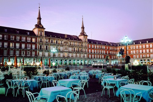 Image white and blue chairs and tables near brown concrete building during night time