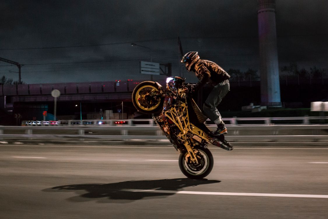 man in black jacket riding on yellow motorcycle