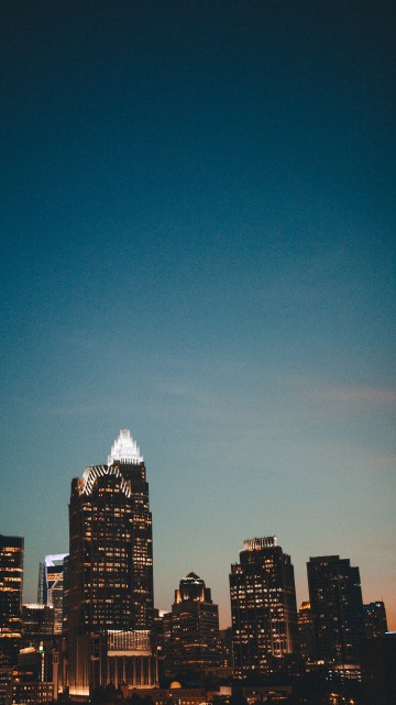 Image city skyline under blue sky during night time