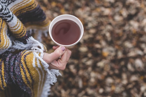 Image person holding white ceramic mug with brown liquid