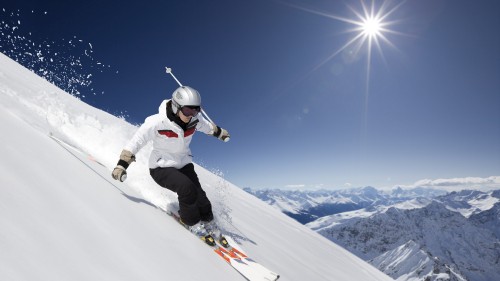 Image person in white snow suit riding on white snow board during daytime