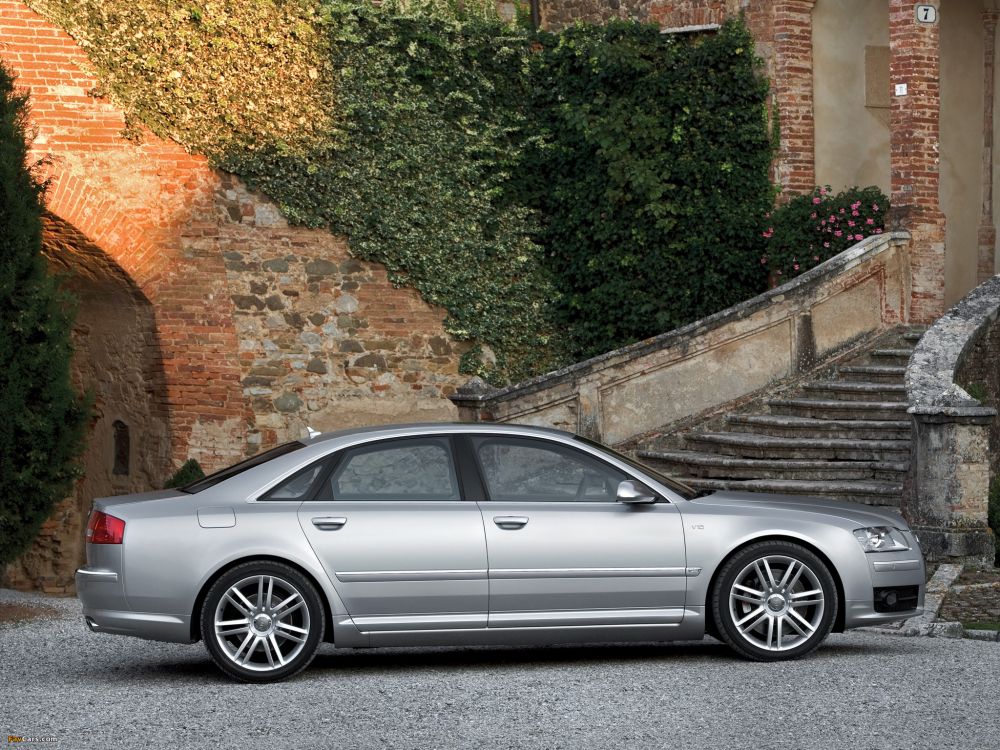 silver sedan parked beside green plant