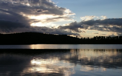 Image body of water near mountain under white clouds and blue sky during daytime