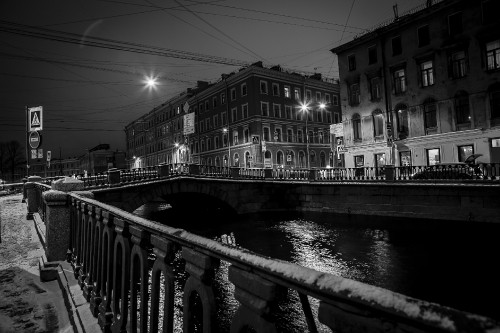 Image grayscale photo of a river in the middle of a city