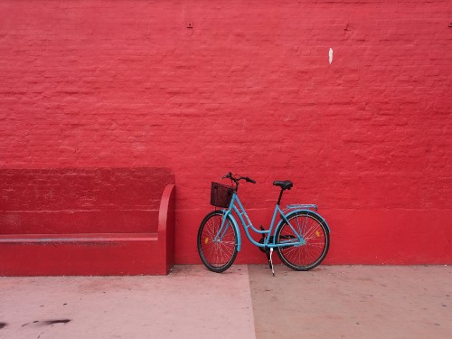 Image black and white city bike beside red wall