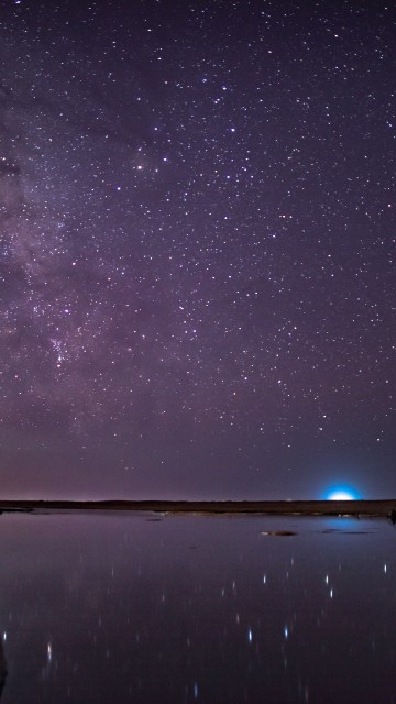 Image brown rock formation on body of water under starry night