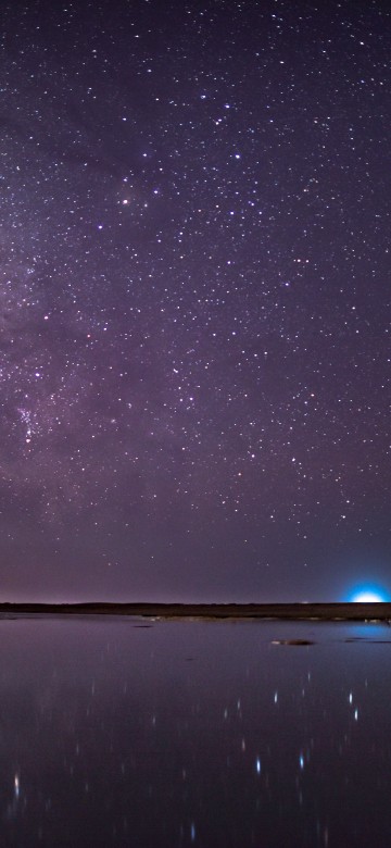 Image brown rock formation on body of water under starry night