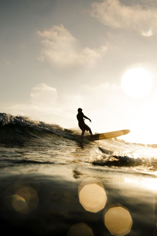 Silhouette Eines Mannes, Der Tagsüber Ein Surfbrett Auf Dem Wasser Hält. Wallpaper in 3648x5472 Resolution