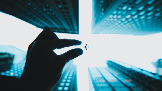 Image person holding black insect on white window