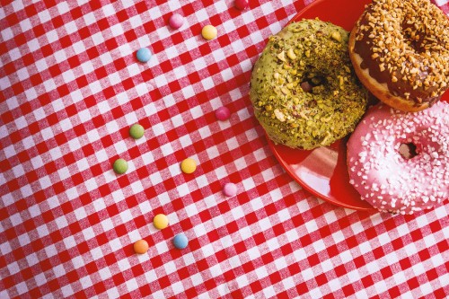 Image brown doughnut on red and white checkered table cloth