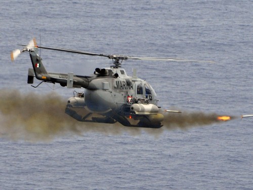 Image gray and black helicopter flying over sea during daytime