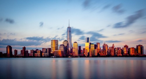 Image city skyline across body of water during daytime