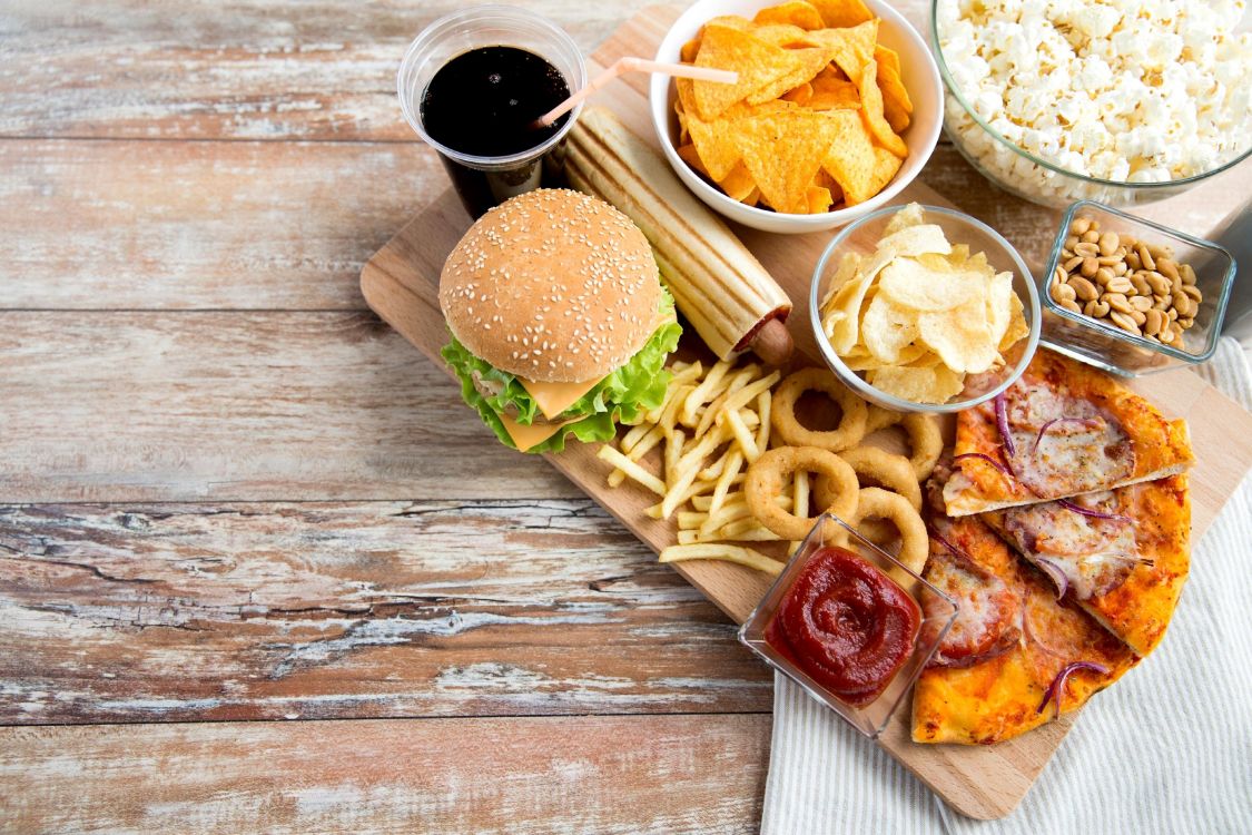 sliced meat with vegetable and sauce on brown wooden chopping board