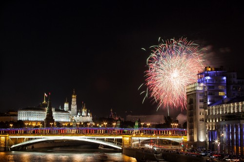 Image fireworks display over city buildings during night time