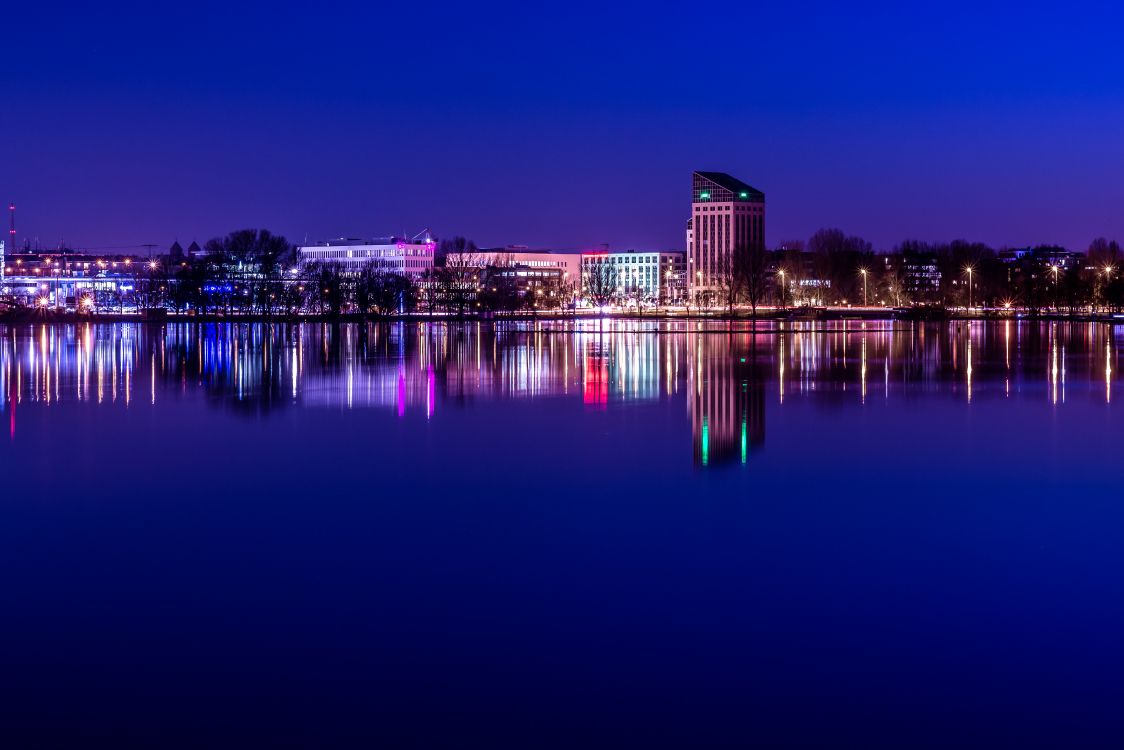 Brown Concrete Building Near Body of Water During Night Time. Wallpaper in 5287x3525 Resolution