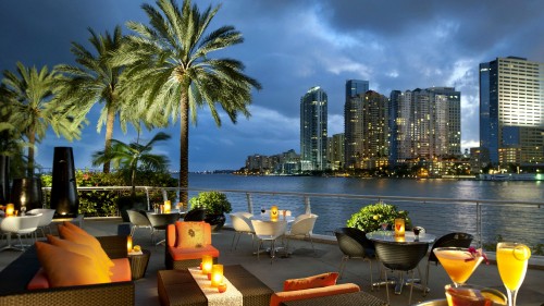 Image brown and white dining table and chairs near body of water during daytime