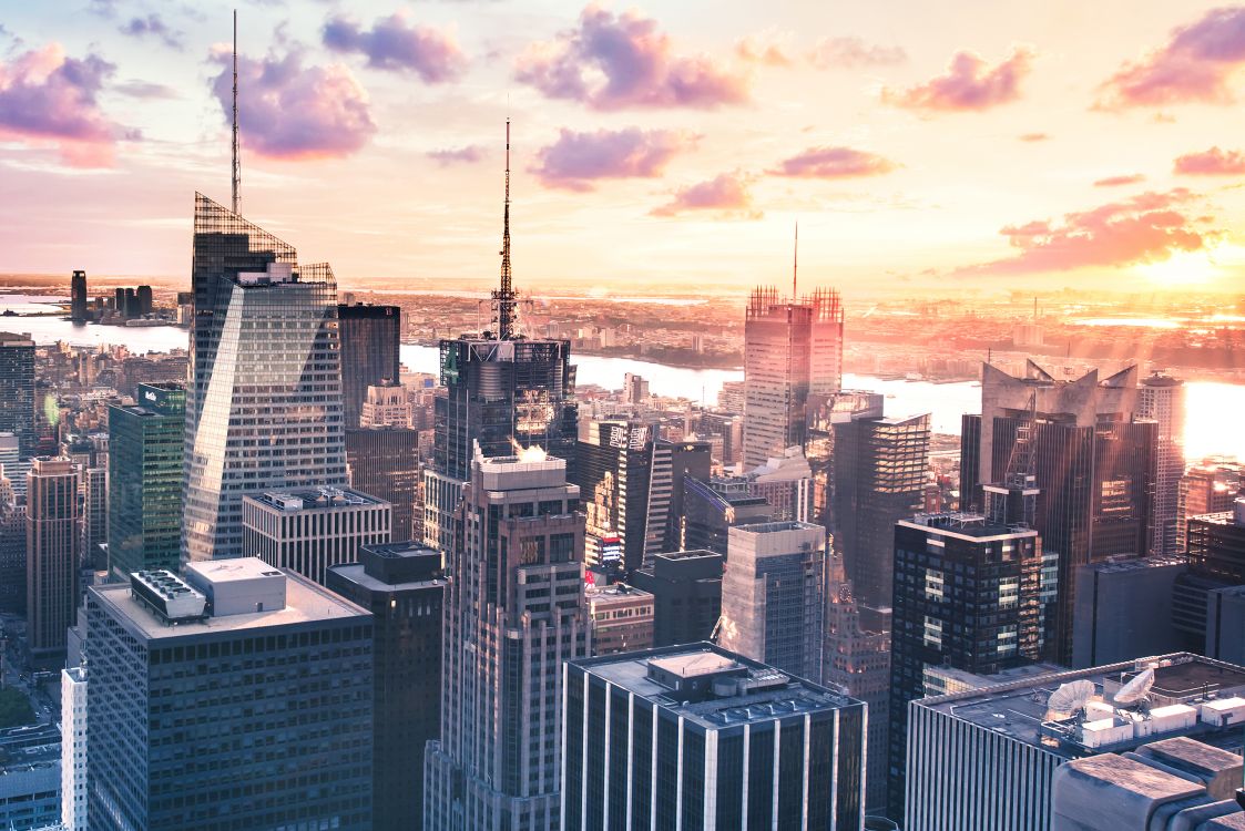 Skyline Der Stadt Unter Orange Und Grau Bewölktem Himmel Bei Sonnenuntergang. Wallpaper in 2560x1709 Resolution