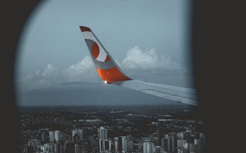 Image white and orange airplane wing during daytime