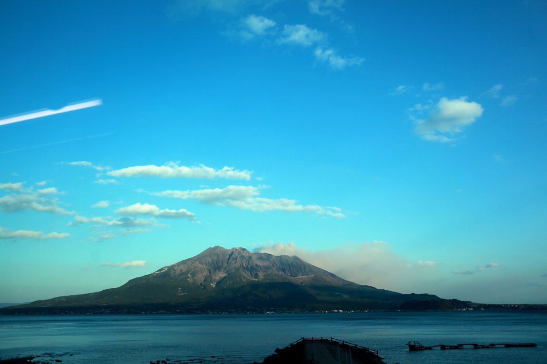 Montagne Verte Près D'un Plan D'eau Sous un Ciel Bleu Pendant la Journée. Wallpaper in 2784x1856 Resolution