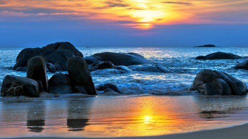 Image gray rock formation on sea during sunset