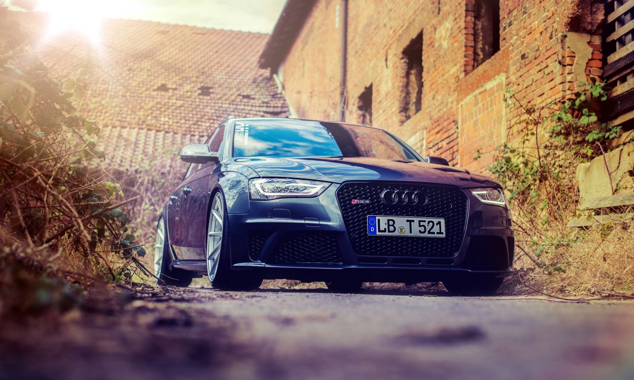 black audi r 8 parked beside brown brick wall