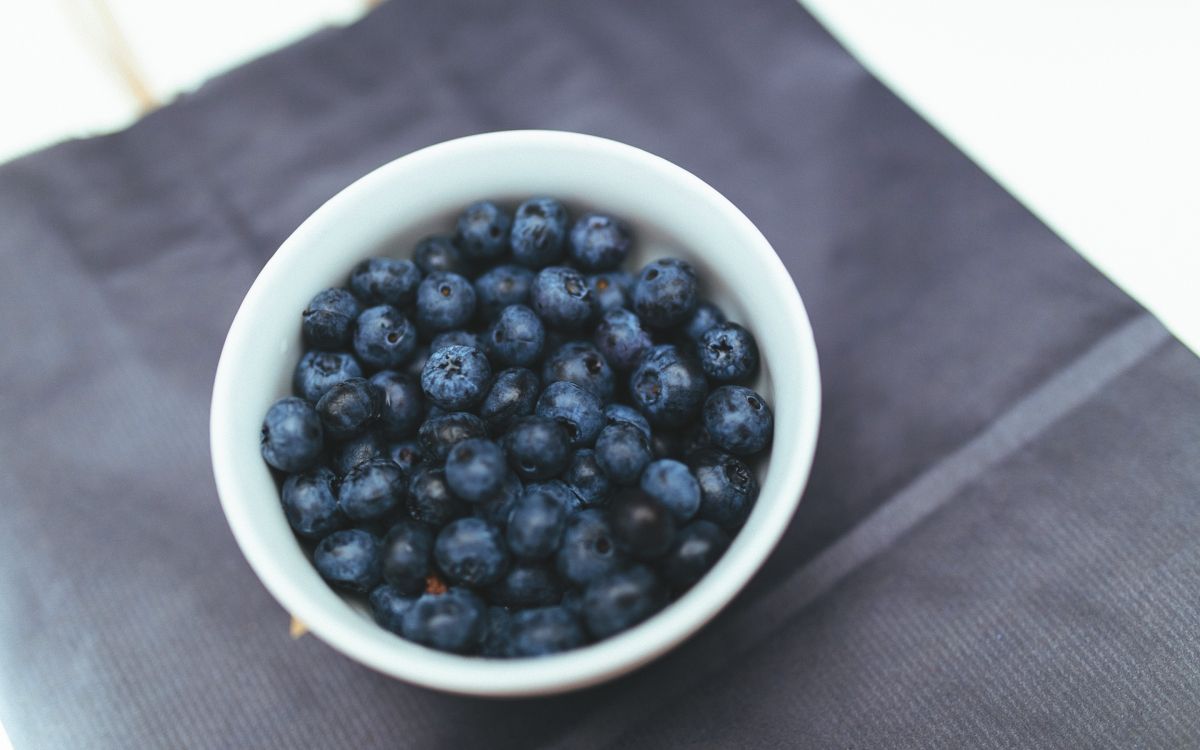 black round fruits in white ceramic bowl