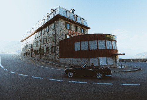 Image black coupe parked beside brown concrete building during daytime