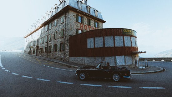 Image black coupe parked beside brown concrete building during daytime