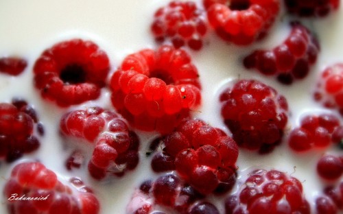 Image red raspberries on white ceramic plate