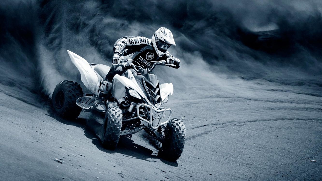 man riding atv on gray sand