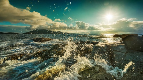 Image ocean waves crashing on rocks under blue sky during daytime