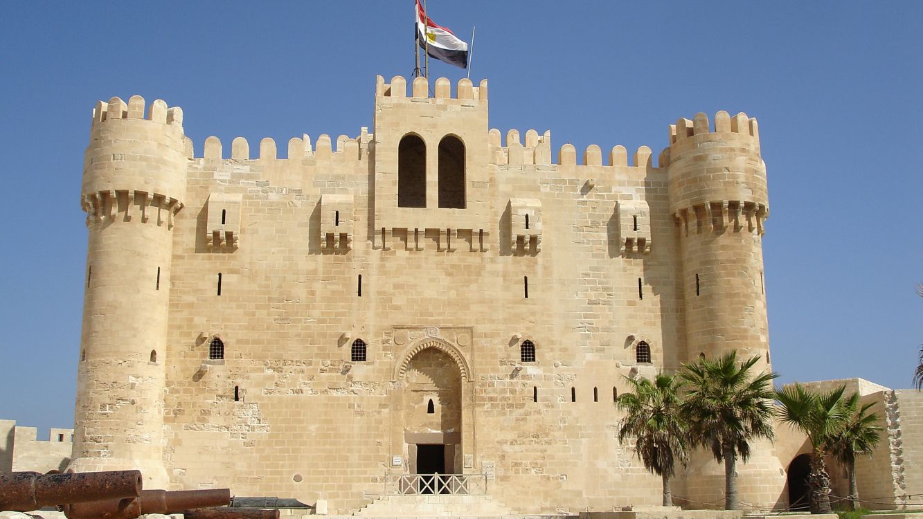 brown concrete building with flags during daytime