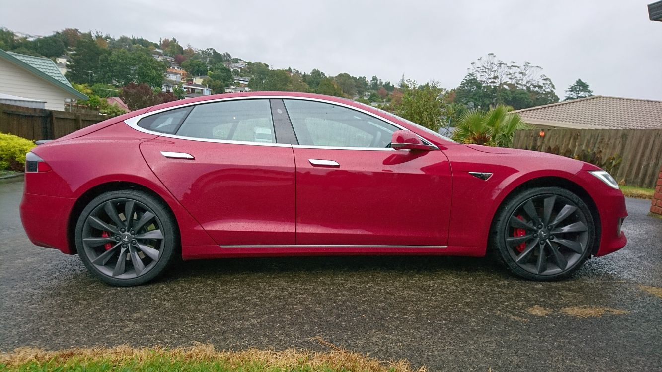 red sedan on green grass field during daytime