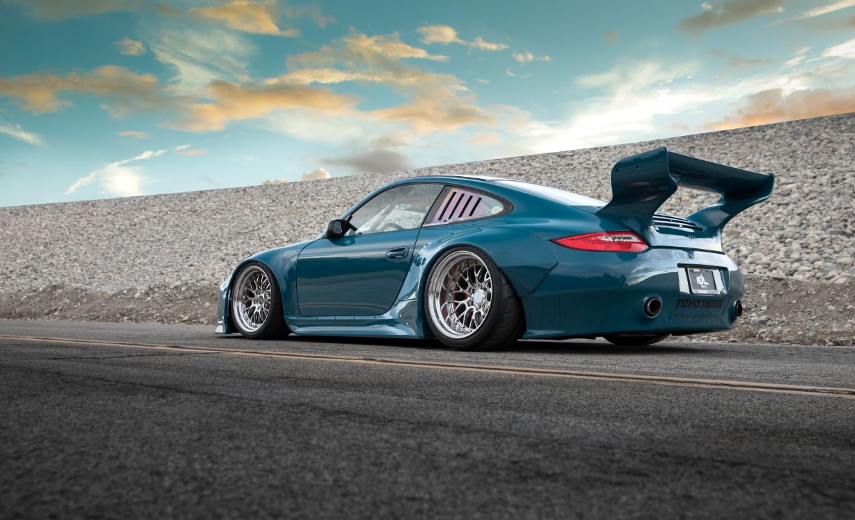 Porsche 911 Azul en la Carretera Bajo un Cielo Azul. Wallpaper in 6648x4042 Resolution