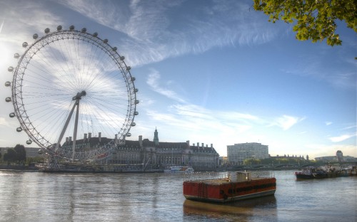 Image ferris wheel near body of water under blue sky during daytime