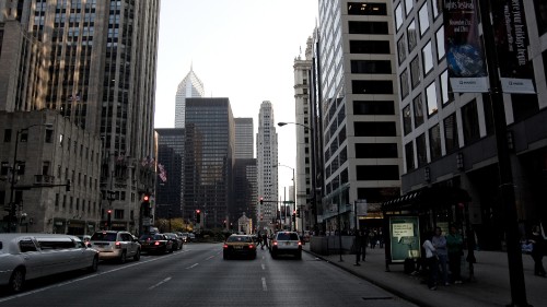 Image cars on road between high rise buildings during daytime