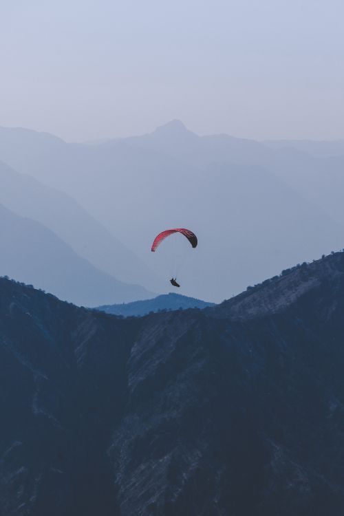 Persona en Paracaídas Naranja Sobre Montañas Verdes Durante el Día. Wallpaper in 4000x6000 Resolution