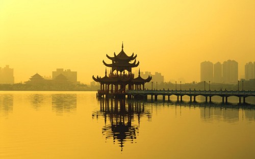 Image silhouette of building near body of water during sunset