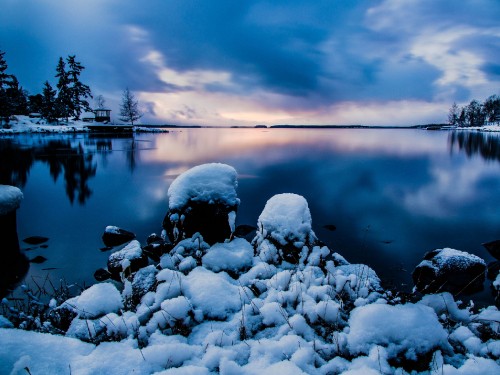 Image gray rocks on body of water under cloudy sky during daytime